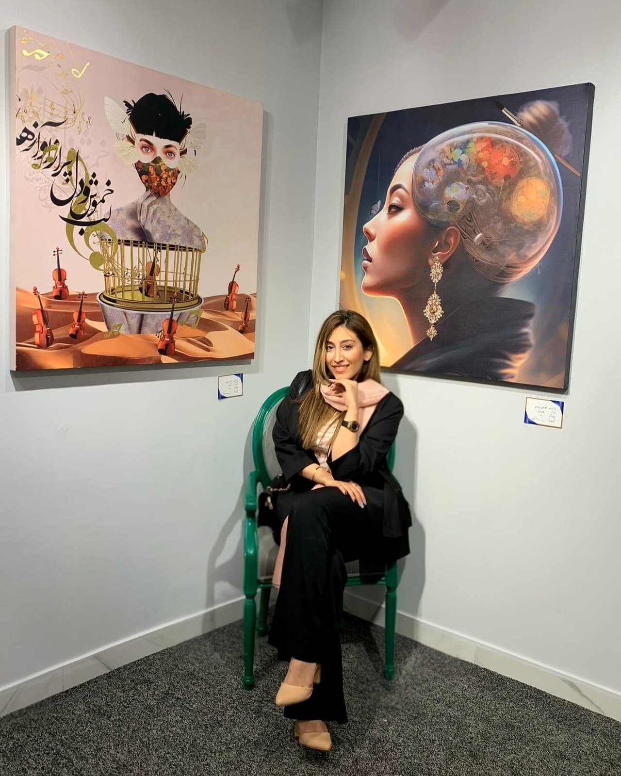 Soha Fazeli seated in front of two of her works at an exhibition